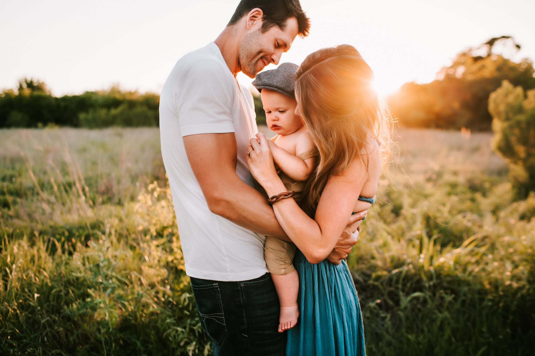 Family embracing in a golden sunset field