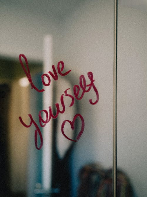 Woman practicing self-esteem counseling and self-compassion with love yourself message