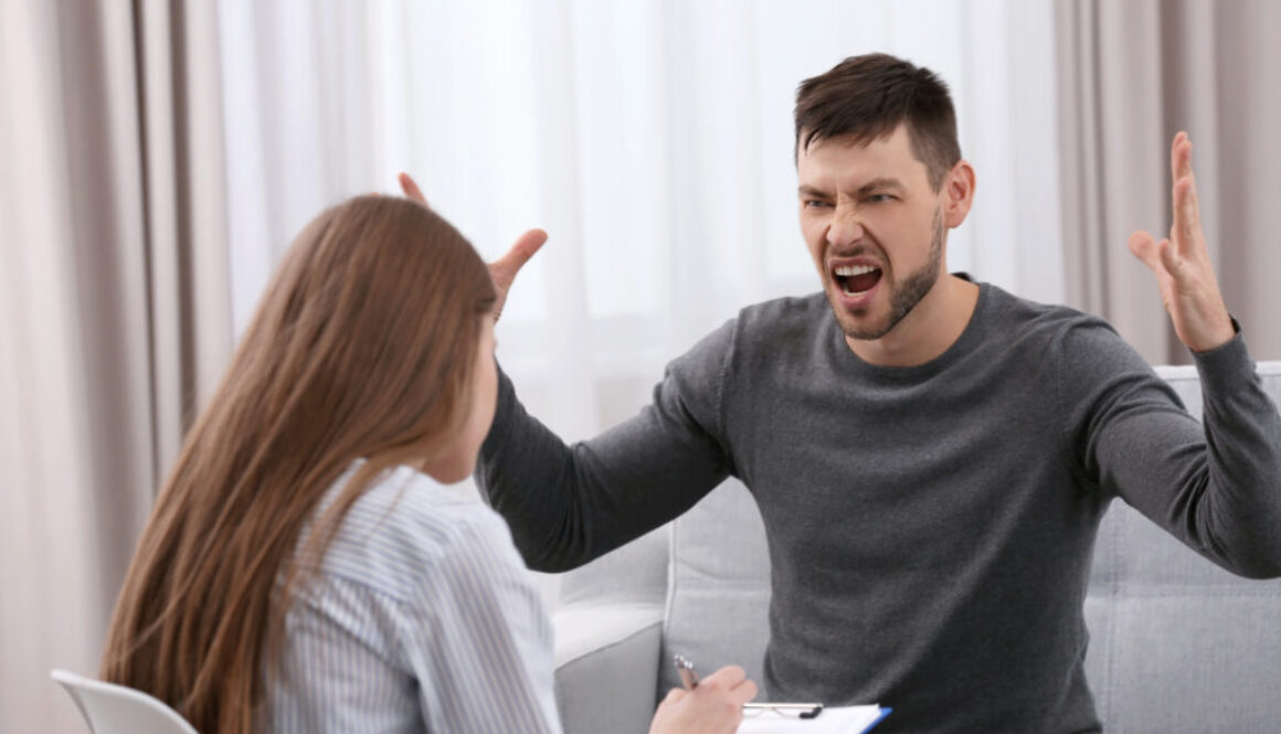 Man expressing anger during an anger management counseling session with a therapist