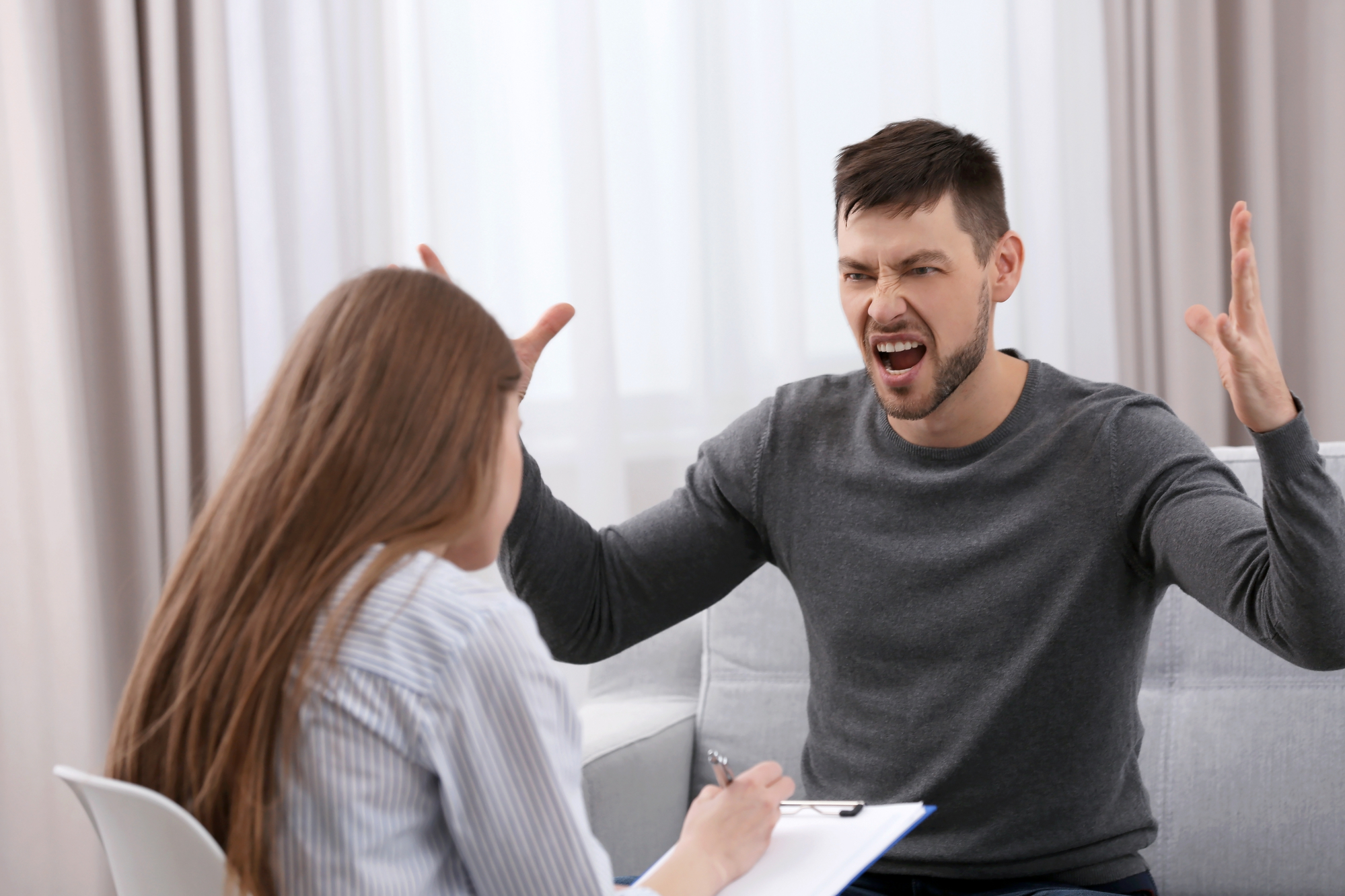 Man expressing anger during an anger management counseling session with a therapist
