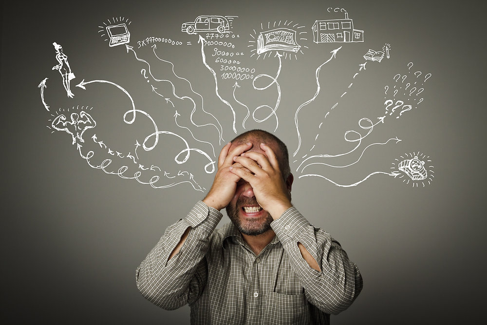 Man with hands over his face, overwhelmed by intrusive thoughts depicted as scribbled arrows